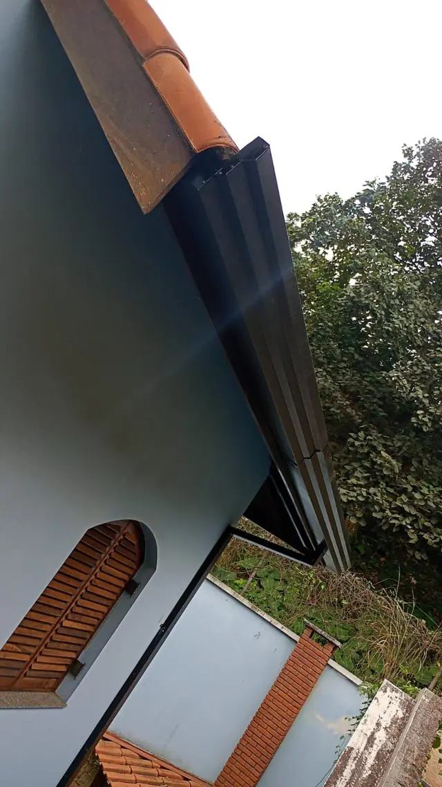 Calha preta instalada em beiral de telhado colonial