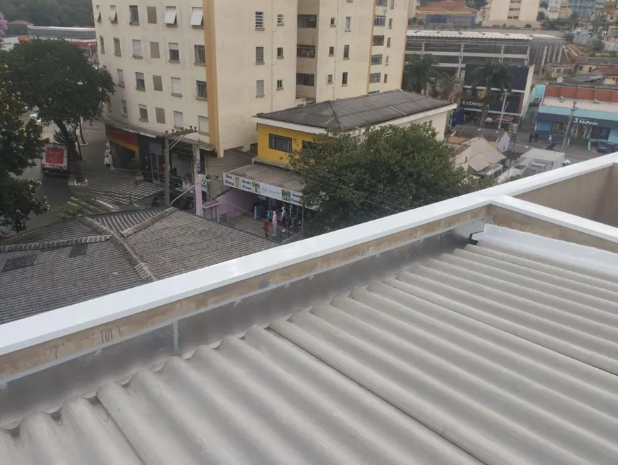 Rufo pingadeira branco no topo da platibanda, com rufo de encosto sobre telhado de fibrocimento