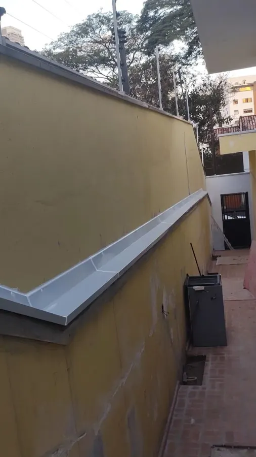 Rufo de chapa clara instalado ao longo do degrau de um muro de divisa